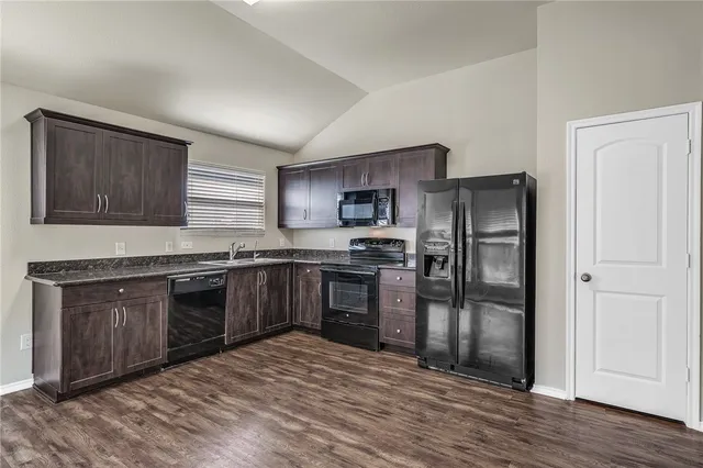 a kitchen with granite countertop stainless steel appliances and wooden cabinets