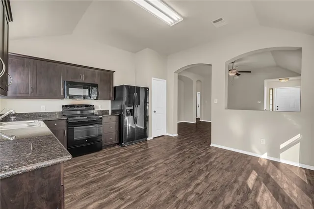 a kitchen with granite countertop stainless steel appliances and wooden cabinets