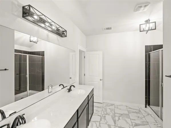 a en suite bathroom with a granite countertop sink and a mirror