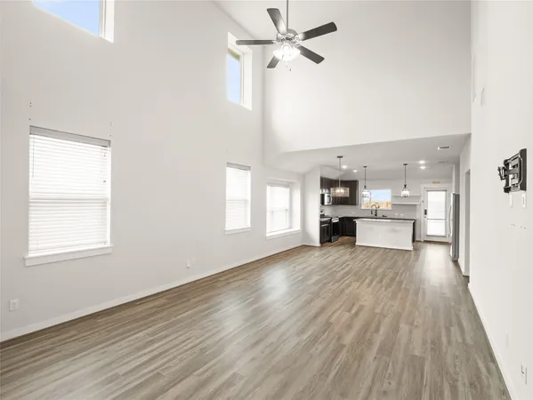 a view of a kitchen with wooden floor electronic appliances and window