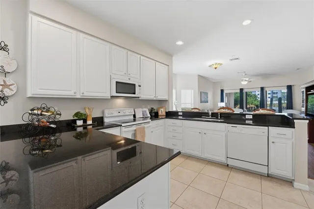 a kitchen with stainless steel appliances granite countertop a sink and white cabinets