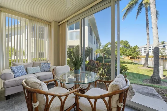 a dining room with furniture water view and a floor to ceiling window
