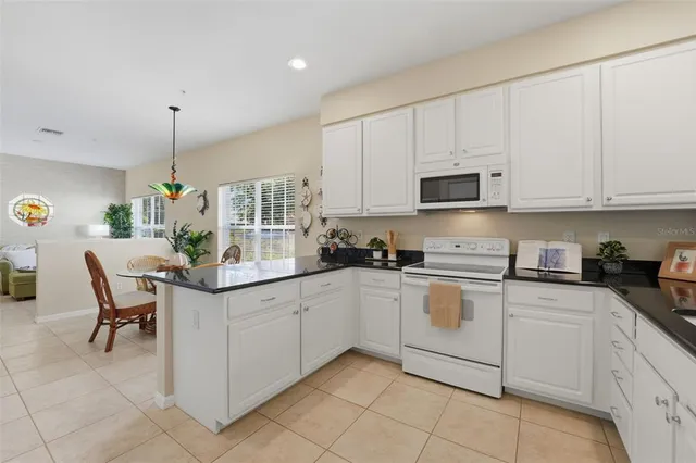 a kitchen with white cabinets and white appliances