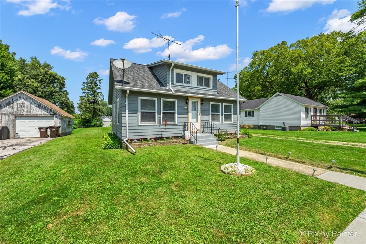 335 Ogden Street Capron, IL 61012 - Photo 2 of 18 a house with green field in front of it