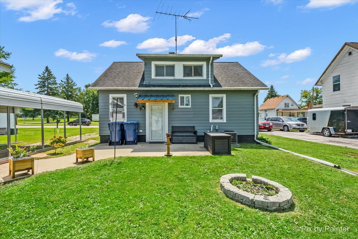 335 Ogden Street Capron, IL 61012 - Photo 6 of 18 a front view of a house with a yard table and chairs