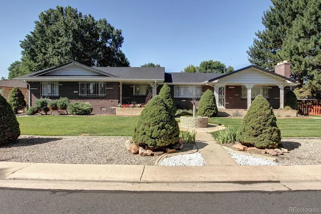 a front view of a house with a yard and potted plants