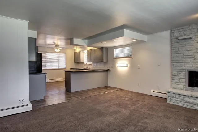 a view of an empty room with wooden floor and window