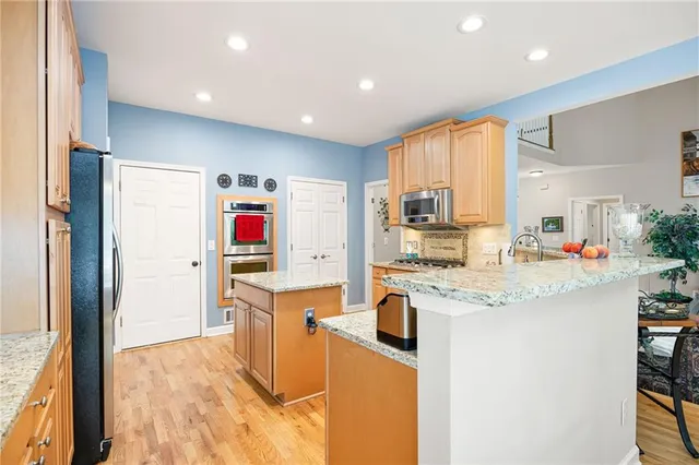 a kitchen with stainless steel appliances granite countertop a sink and cabinets