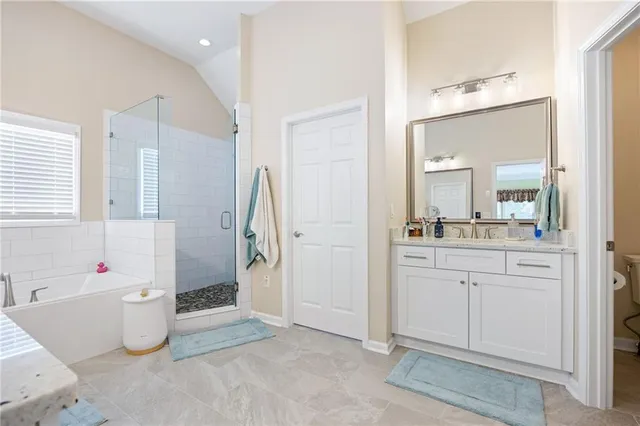 a bathroom with a double vanity sink a mirror and a bathtub