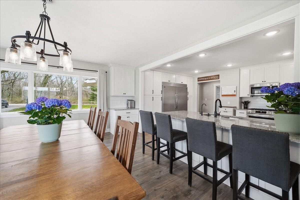 6411 East 129th Avenue Crown Point, IN 46307 - Photo 11 of 79 a dining room with furniture potted plants and wooden floor