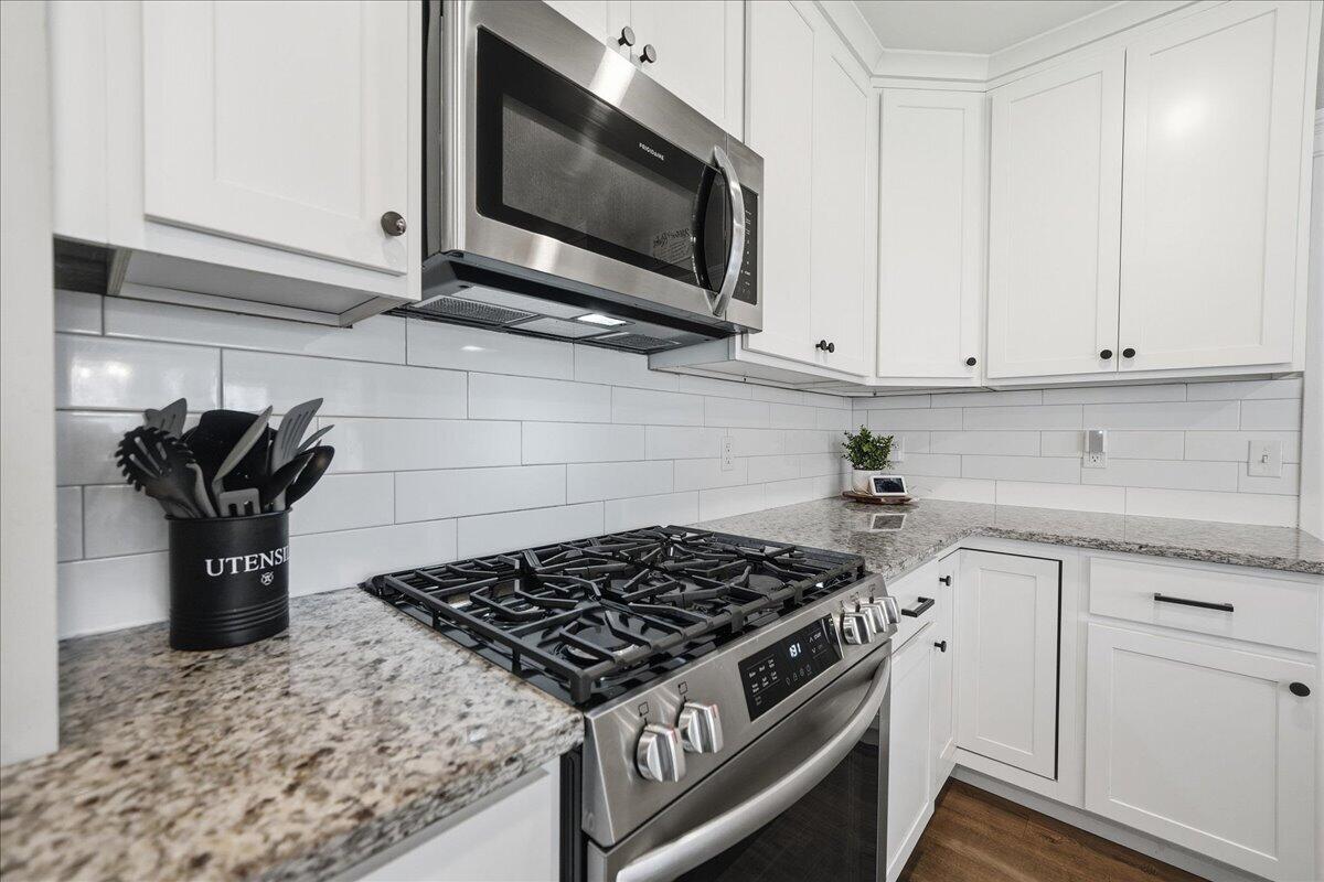 6411 East 129th Avenue Crown Point, IN 46307 - Photo 12 of 79 a kitchen with microwave a stove and cabinets