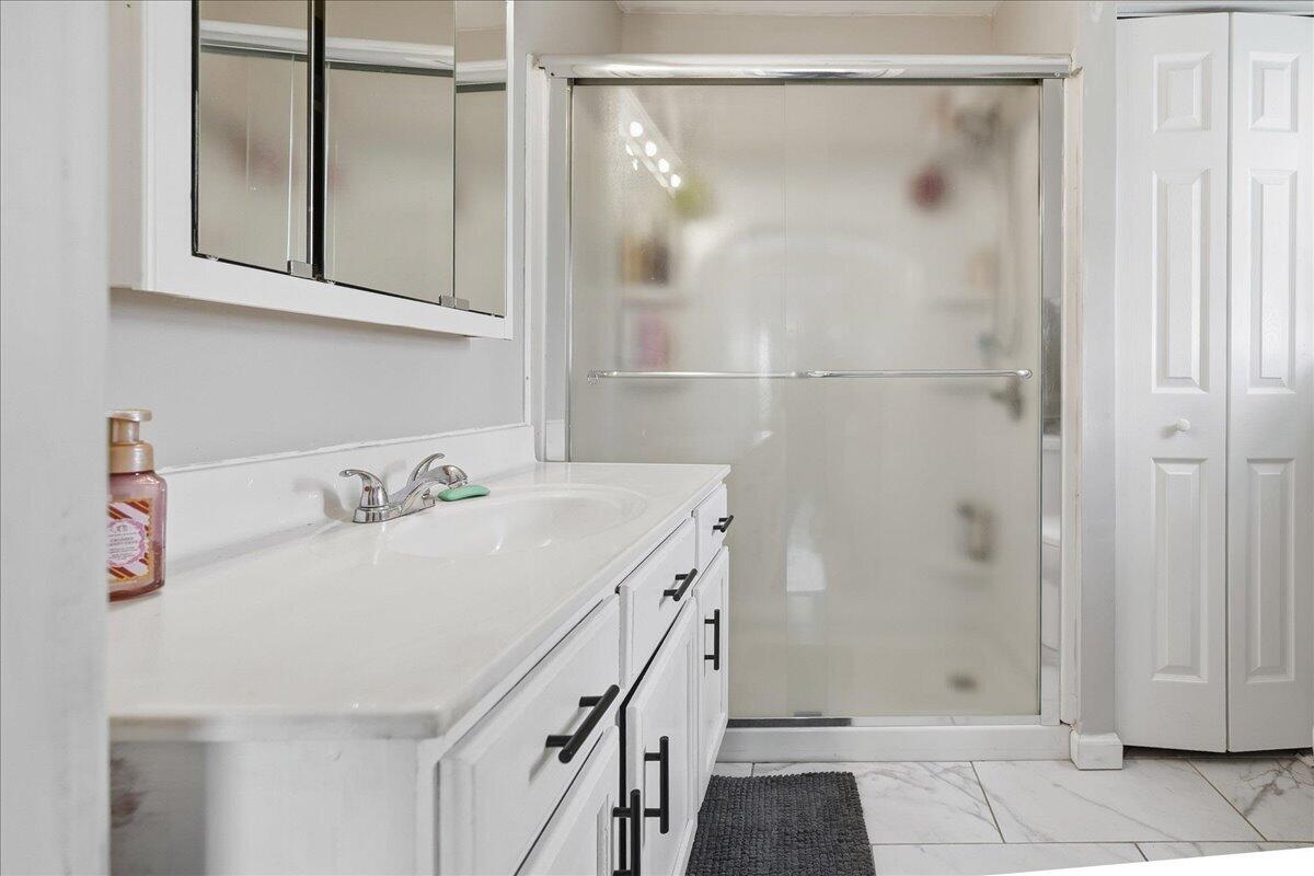 6411 East 129th Avenue Crown Point, IN 46307 - Photo 56 of 79 a bathroom with a granite countertop sink a mirror and shower