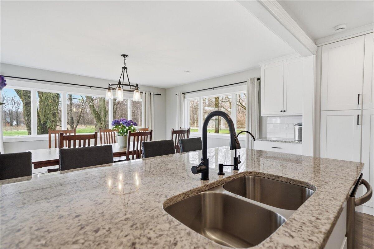 6411 East 129th Avenue Crown Point, IN 46307 - Photo 7 of 79 a kitchen with a faucet a sink and a wooden floor