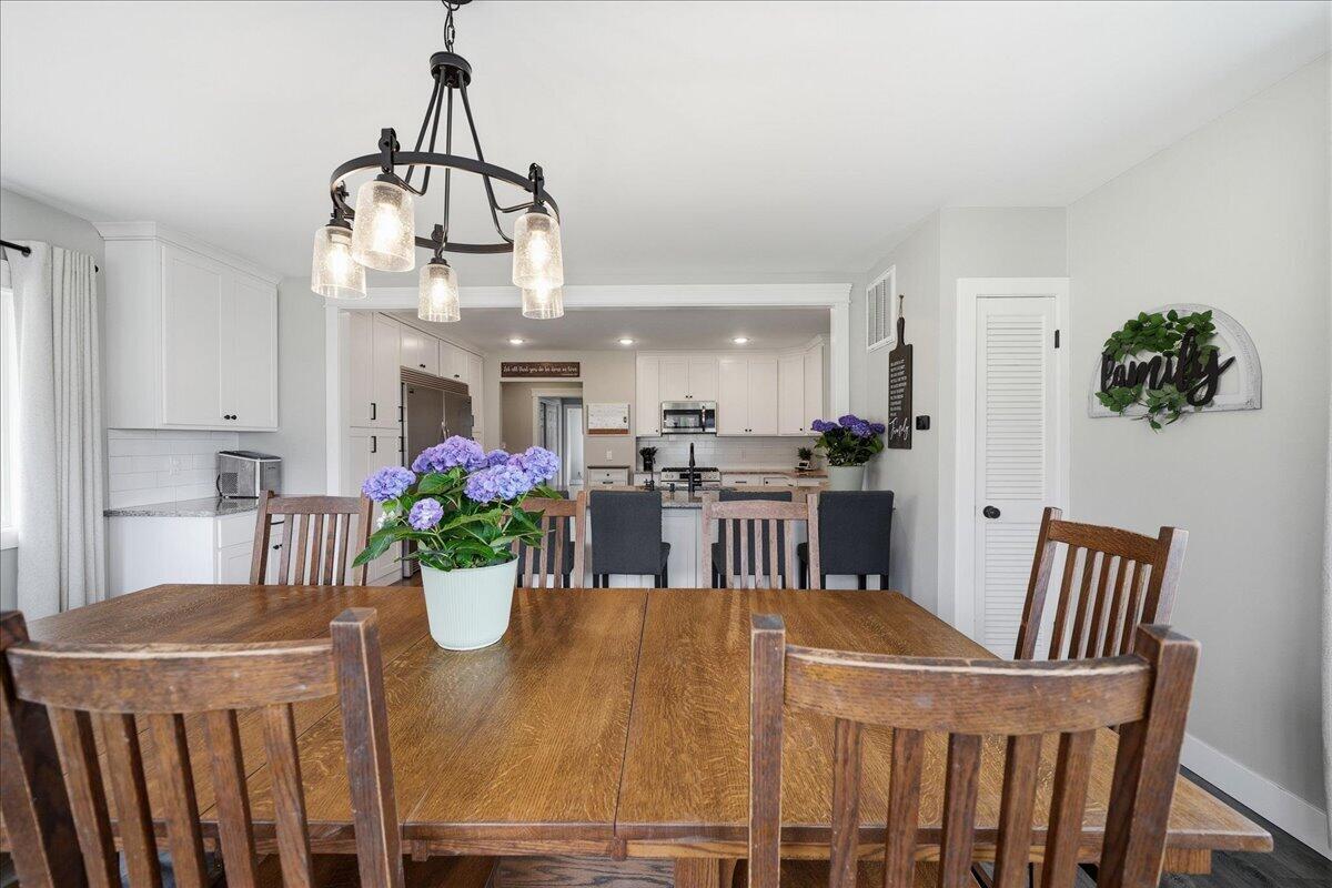 6411 East 129th Avenue Crown Point, IN 46307 - Photo 10 of 79 a view of a dining room with furniture a chandelier and wooden floor