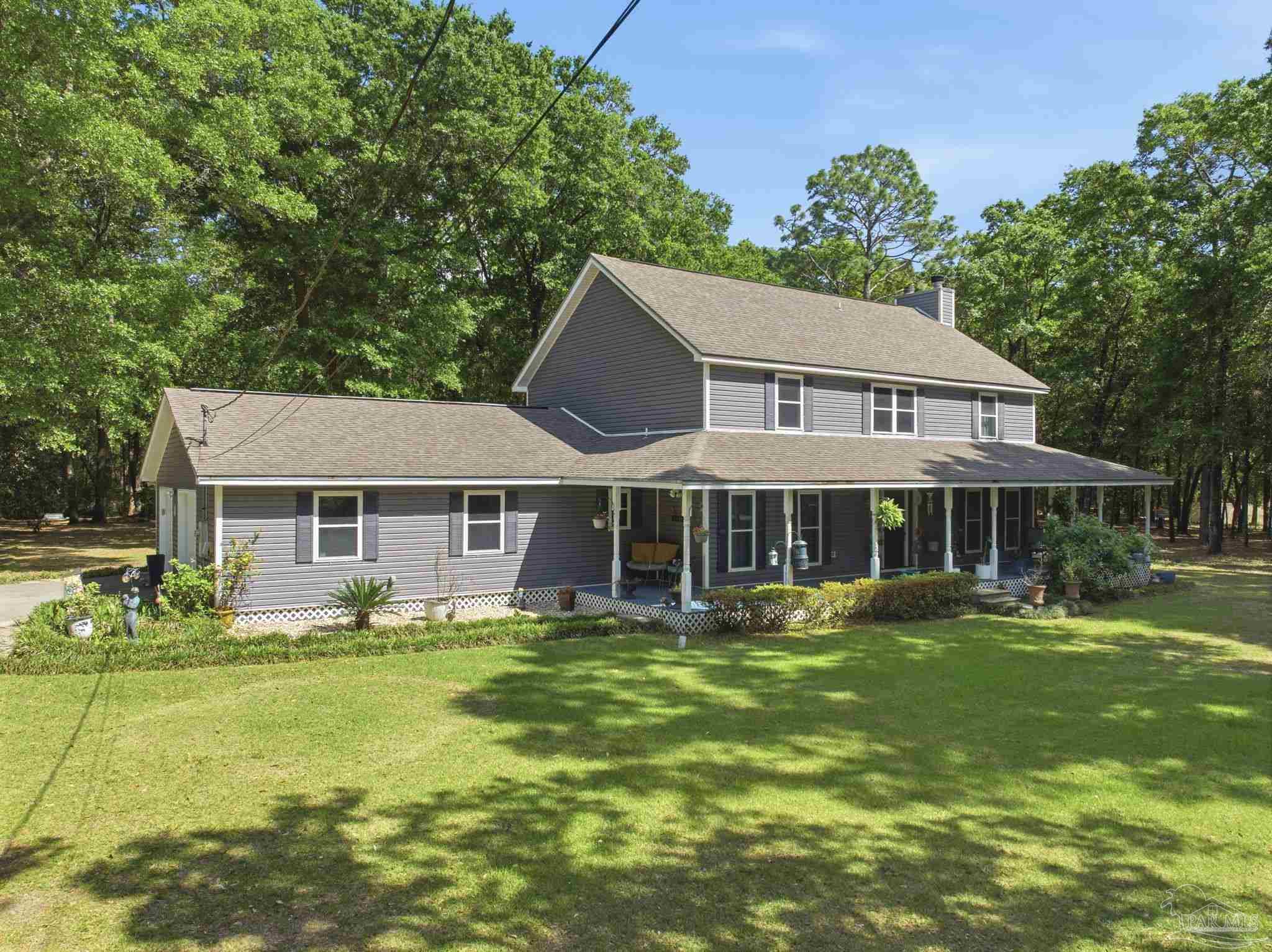 6930 Summit Way Milton, FL 32570 - Photo 1 of 71 a view of a house with a big yard and potted plants and large trees