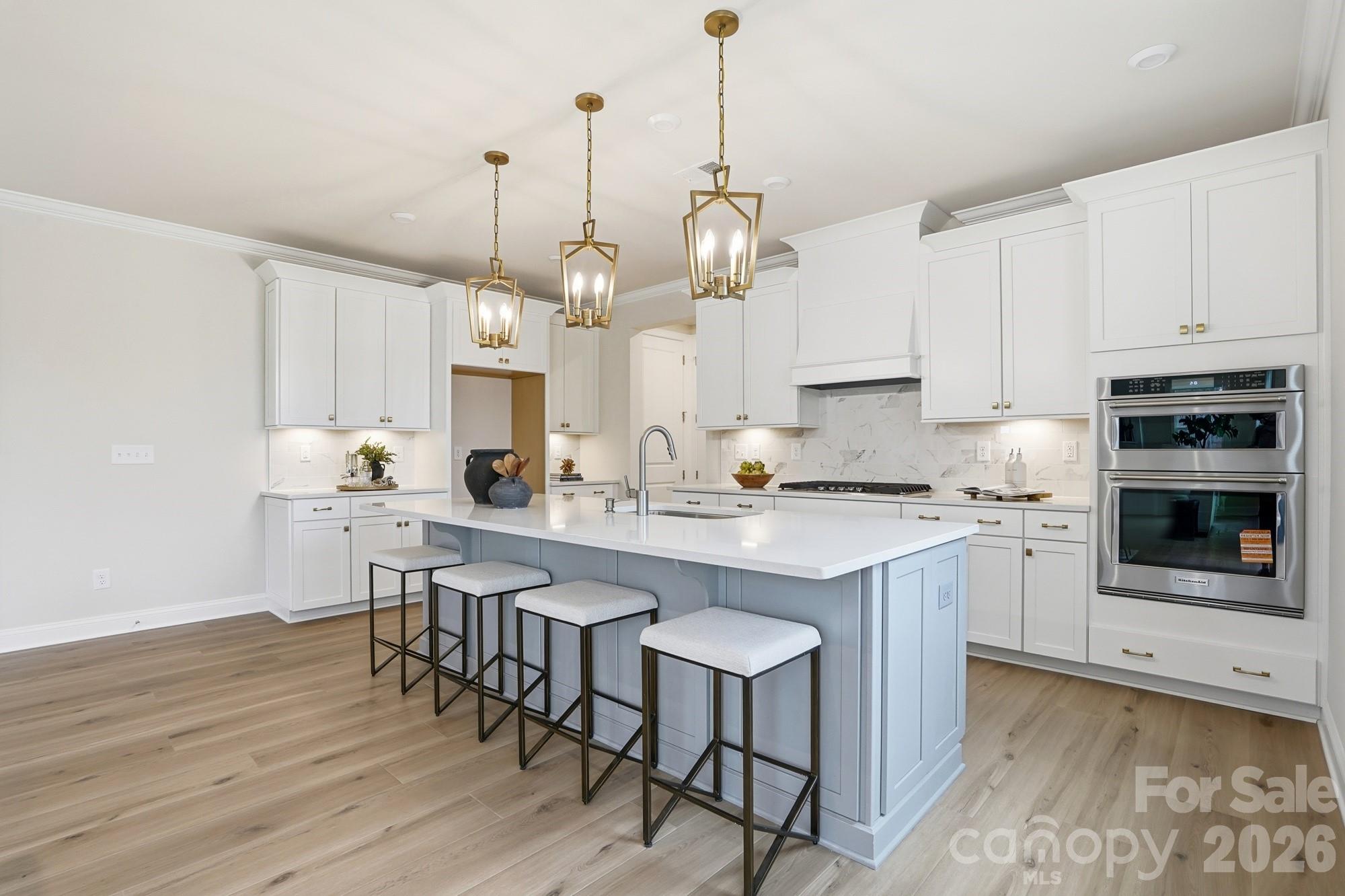 2549 Mabel Lane Monroe, NC 28110 - Photo 10 of 28 a large kitchen with stainless steel appliances a stove a sink a island with a dining table and chairs