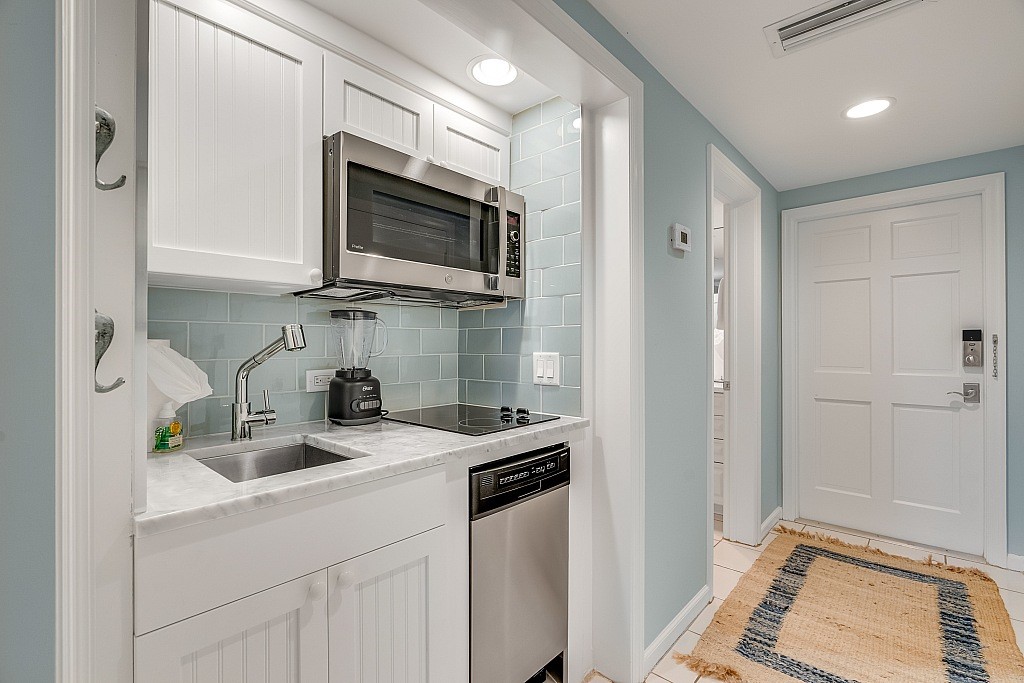 400 Beach Road, Unit 117 Vero Beach, FL 32963 - Photo 4 of 23 a kitchen with stainless steel appliances a sink a stove a microwave and cabinets