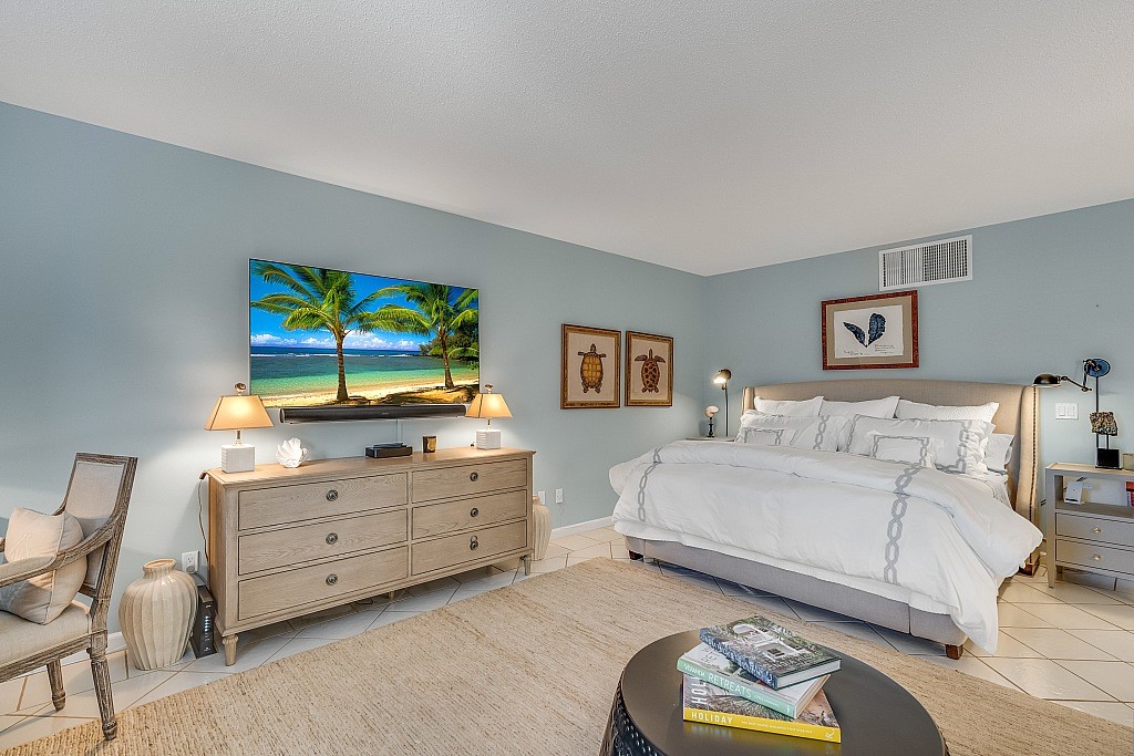 400 Beach Road, Unit 117 Vero Beach, FL 32963 - Photo 9 of 23 a bedroom with a bed and a flat screen tv
