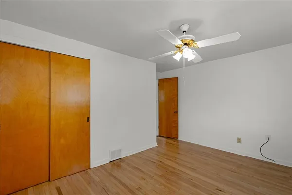 a view of a big room with wooden floor and windows