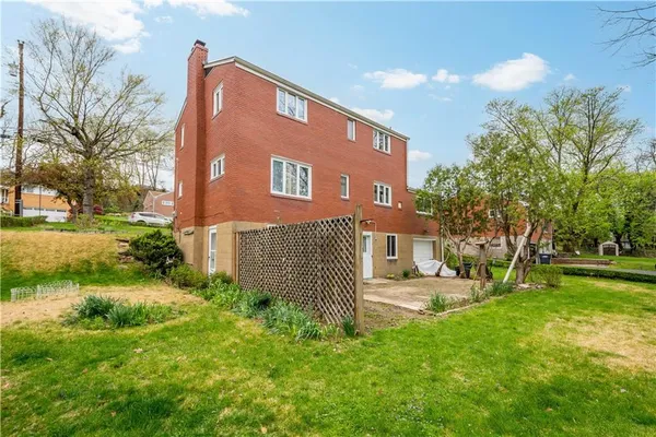 a brick building with a yard and a bench