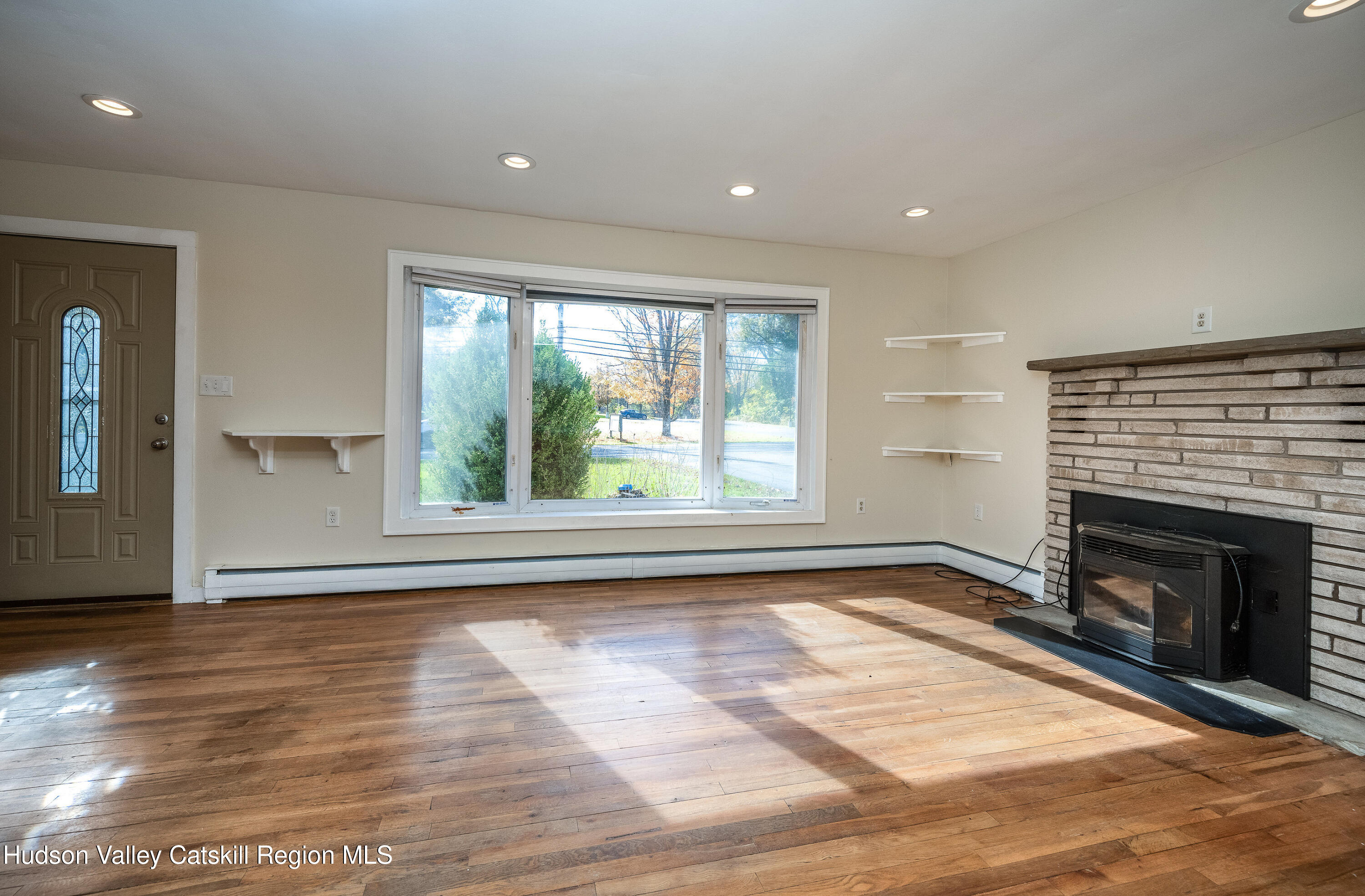 3024 Highway 213 Stone Ridge, NY 12484 - Photo 4 of 31 a view of empty room with wooden floor and fireplace
