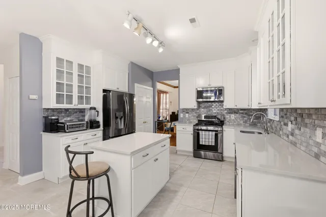 a kitchen with a refrigerator a stove a microwave and island with wooden floor