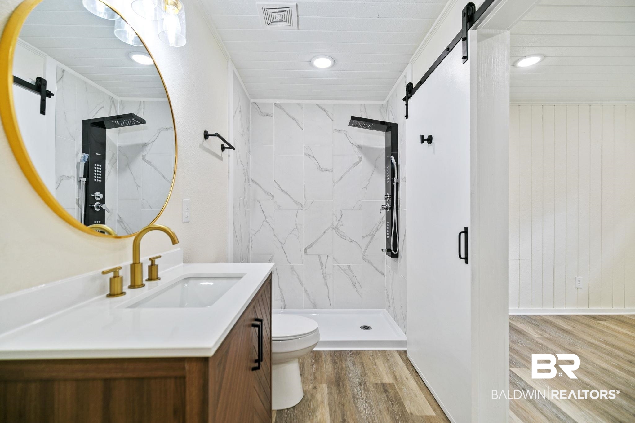 507 Byrne Street Bay Minette, AL 36507 - Photo 19 of 40 Bathroom with vanity, tiled shower, toilet, and hardwood / wood-style flooring