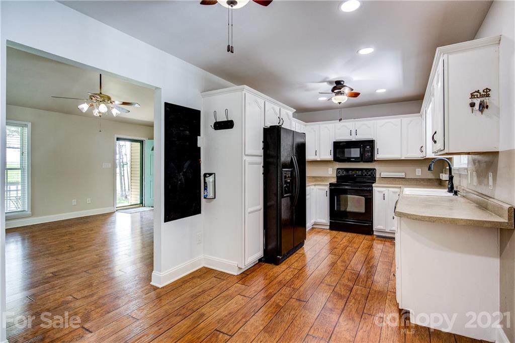 4004 Belk Mill Road Wingate, NC 28174 - Photo 12 of 44 a kitchen with stainless steel appliances kitchen island hardwood floor sink and stove