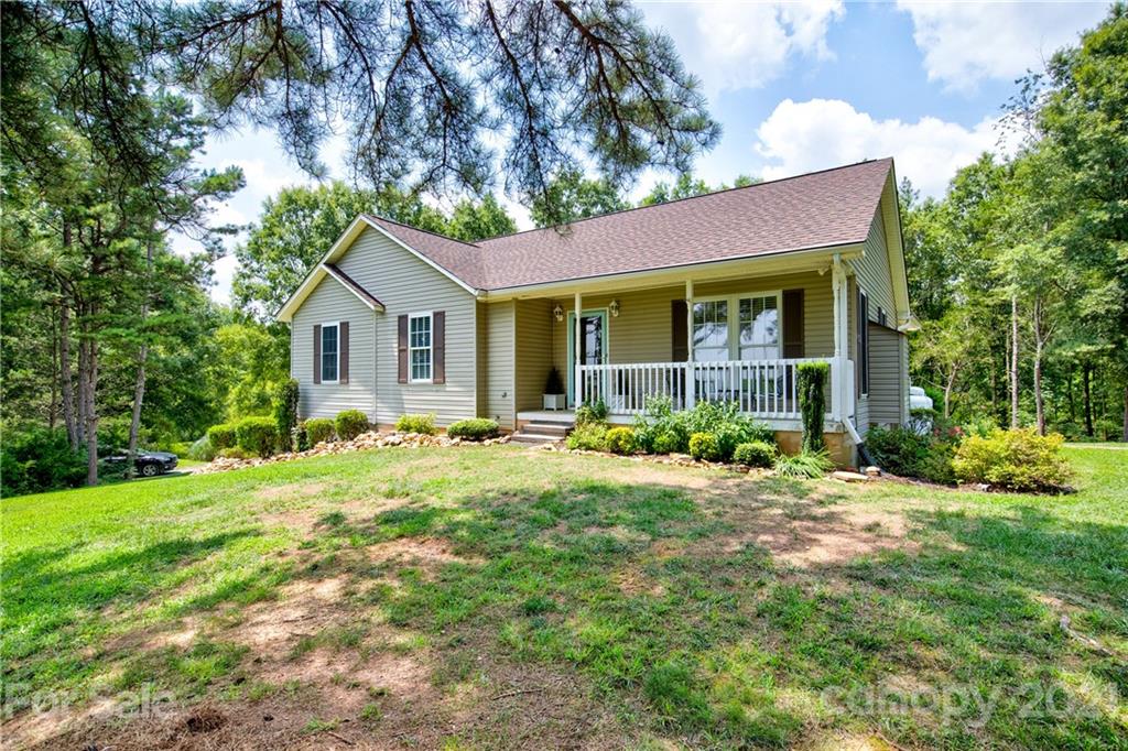 4004 Belk Mill Road Wingate, NC 28174 - Photo 3 of 44 a front view of a house with a yard and trees
