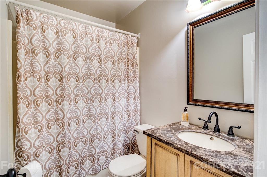 4004 Belk Mill Road Wingate, NC 28174 - Photo 23 of 44 a bathroom with a granite countertop sink and a mirror