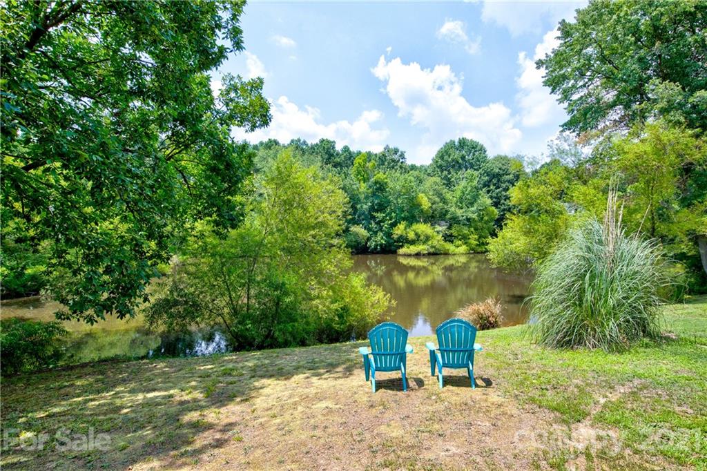 4004 Belk Mill Road Wingate, NC 28174 - Photo 34 of 44 a view of a lake with a bench and trees around
