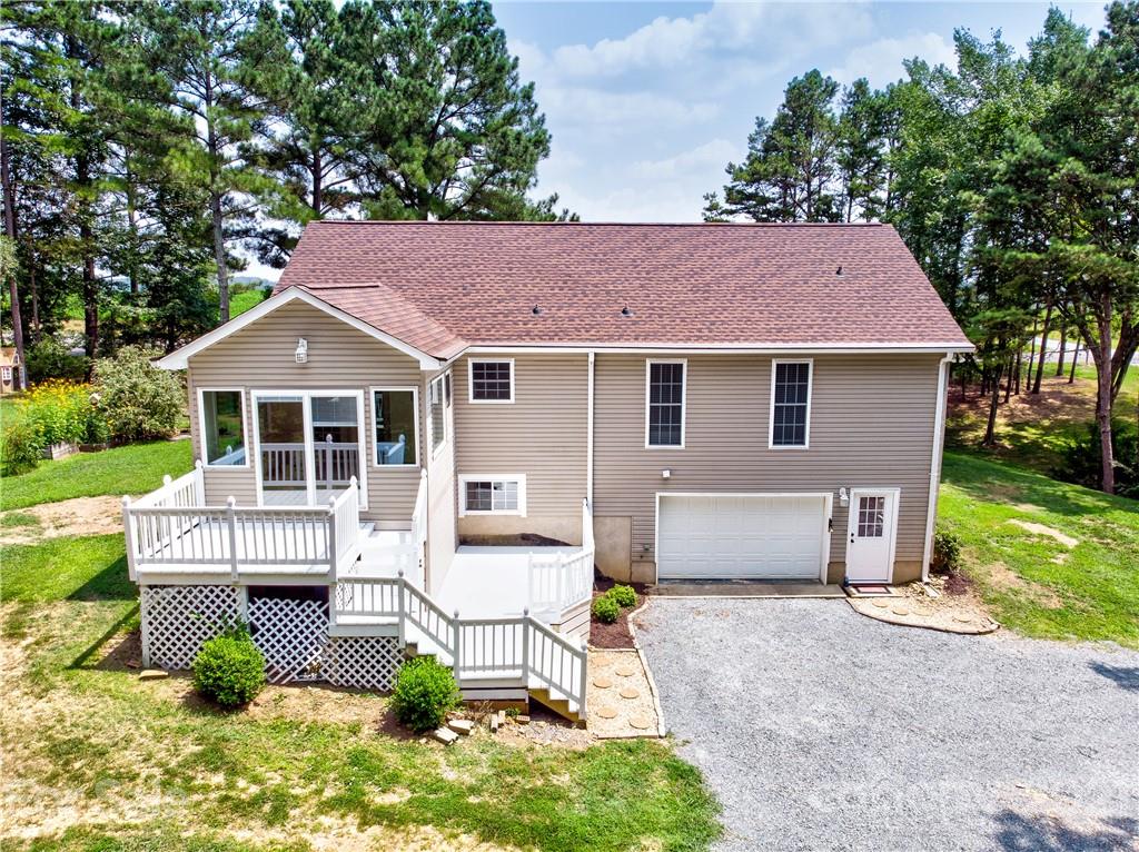 4004 Belk Mill Road Wingate, NC 28174 - Photo 44 of 44 a white house with a yard and table and chairs under an umbrella