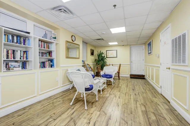 a dining room with furniture a book shelves and wooden floor