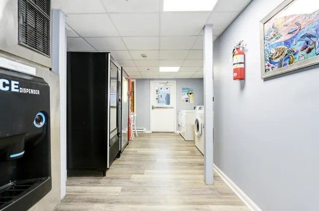 a view of hallway with furniture and refrigerator