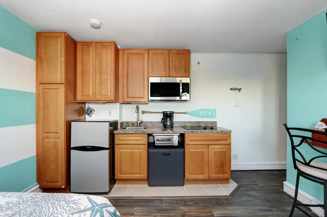 a kitchen with stainless steel appliances granite countertop a stove a sink refrigerator and a microwave