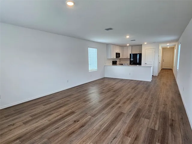 a view of a kitchen with cabinets and wooden floor