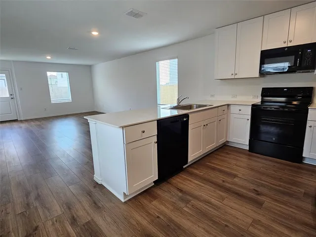 a kitchen with stainless steel appliances granite countertop a stove a sink and a microwave