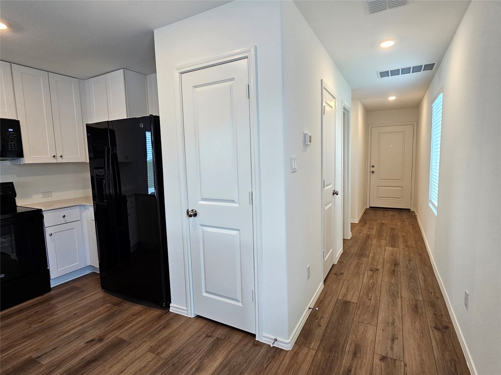 704 Commander Abbott Drive Jarrell, TX 76537 - Photo 8 of 29 a view of a refrigerator in kitchen and wooden floor