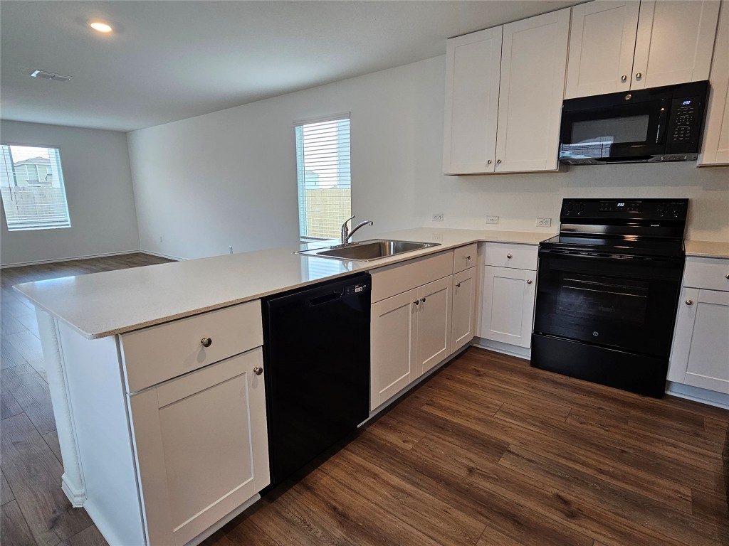 704 Commander Abbott Drive Jarrell, TX 76537 - Photo 10 of 29 a kitchen with stainless steel appliances granite countertop a stove a sink and white cabinets
