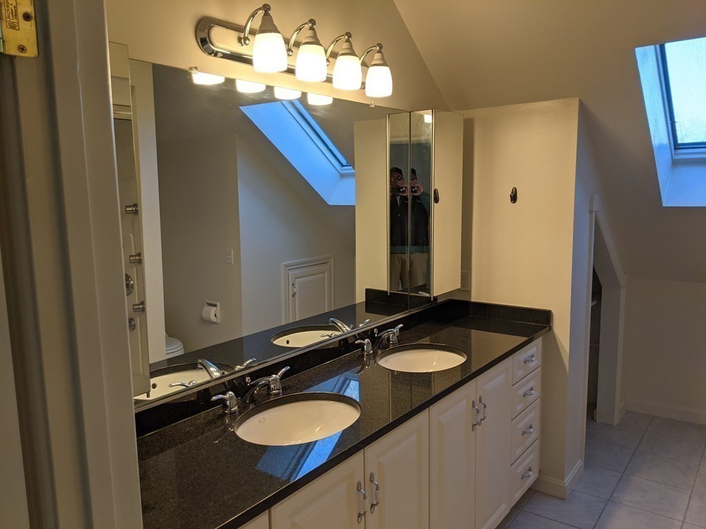 44 Boxford Road, Unit 44 Haverhill, MA 01835 - Photo 8 of 13 a bathroom with a granite countertop sink a large mirror and a shower