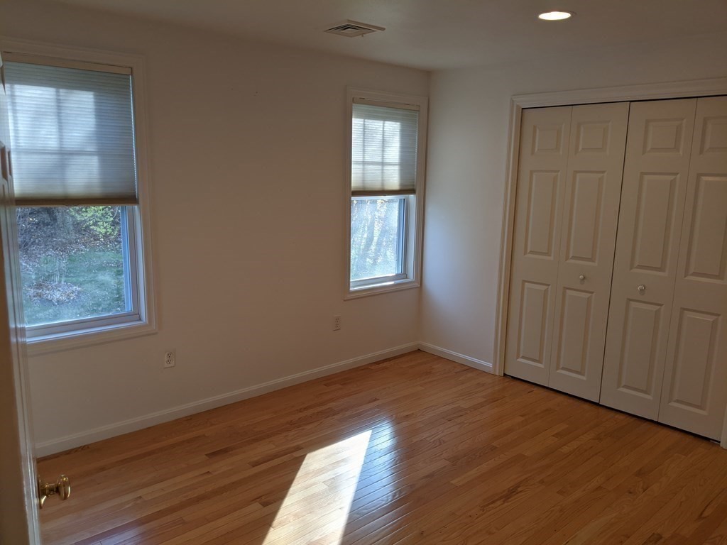 44 Boxford Road, Unit 44 Haverhill, MA 01835 - Photo 9 of 13 an empty room with wooden floor and windows