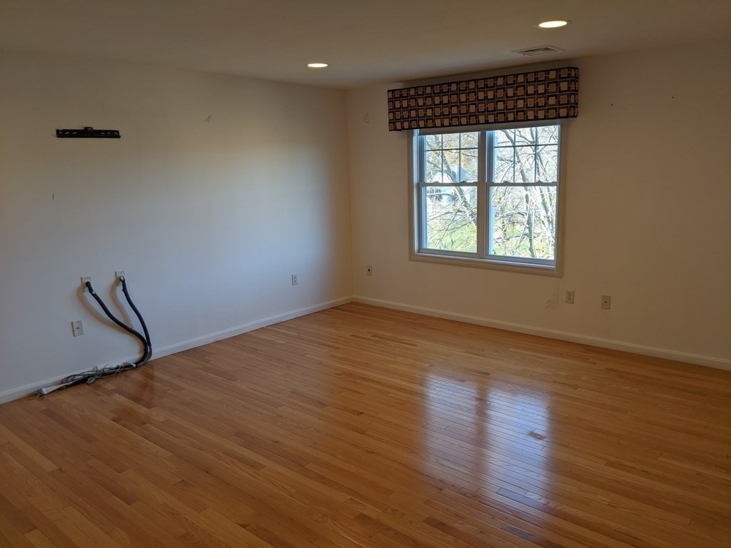 44 Boxford Road, Unit 44 Haverhill, MA 01835 - Photo 10 of 13 an empty room with wooden floor and windows