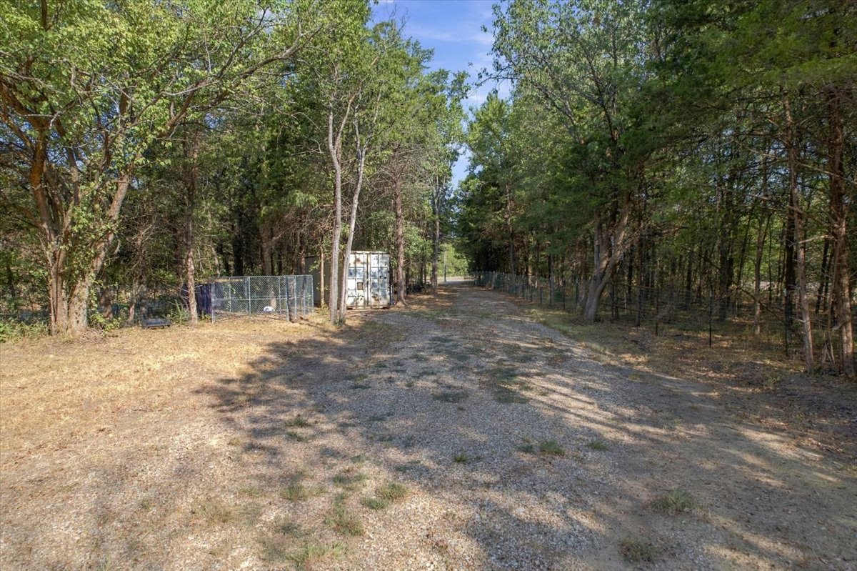 Bloomfield Road Colbert, OK 74733 - Photo 20 of 25 Gravel drive with mature trees and dense foliage