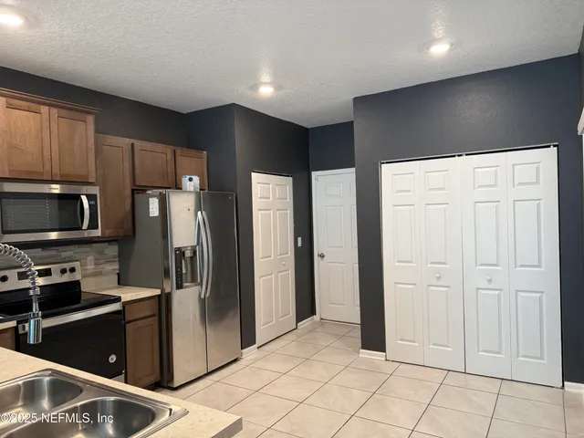 a kitchen with stainless steel appliances granite countertop a refrigerator and a sink