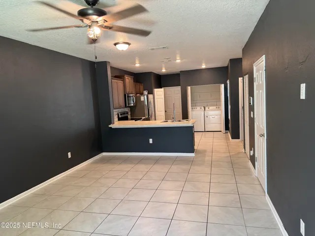a view of a kitchen with a sink and a refrigerator