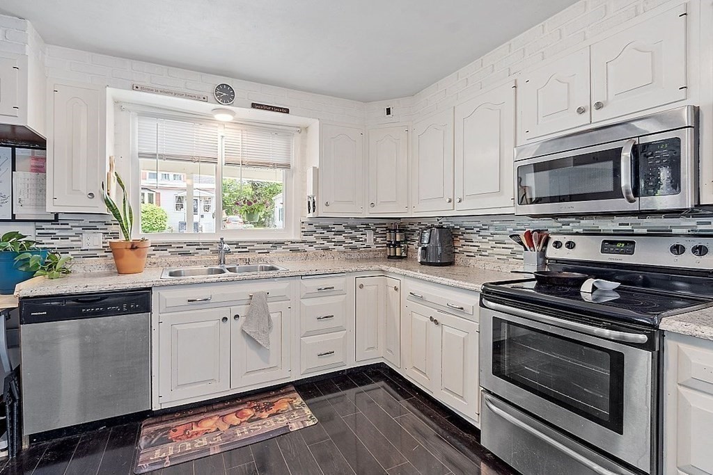 84 Euclid Street Gardner, MA 01440 - Photo 7 of 28 a kitchen with stainless steel appliances white cabinets granite counter tops and a window