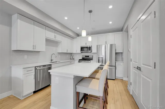 a kitchen that has a lot of cabinets in it and wooden floors