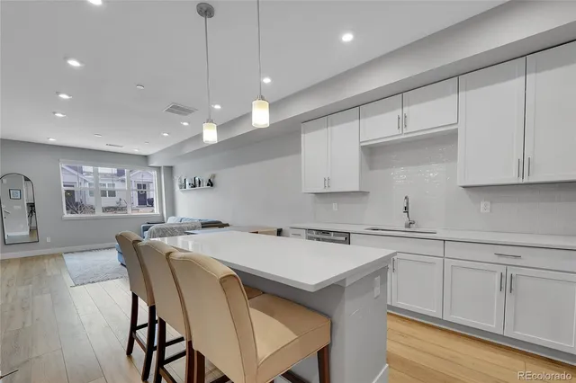 a kitchen with a table chairs sink and cabinets