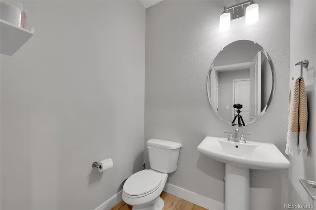 a bathroom with a toilet sink and mirror