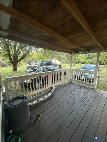 a view of deck with furniture and trees in the background